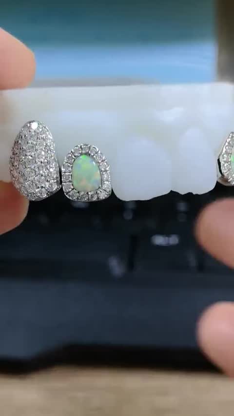 Finished set with an opal center stone, white gold